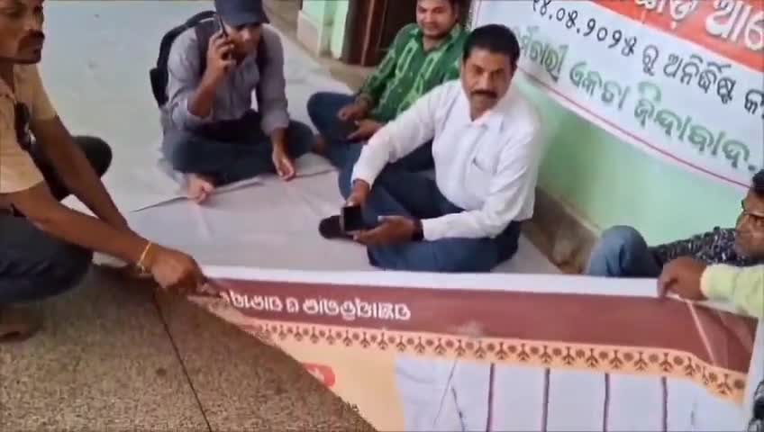 ସୋନପୁର: ବିରାମହାରାଜପୁରରେ ପ୍ରଧାନମନ୍ତ୍ରୀ ଓ ମୁଖ୍ୟମନ୍ତ୍ରୀଙ୍କ ଫଟୋ ଥିବା ବ୍ୟାନରରେ ବସି ଆନ୍ଦୋଳନ କଲେ କର୍ମଚାରୀ, ଥାନାରେ ଲିଖିତ ଅଭିଯୋଗ