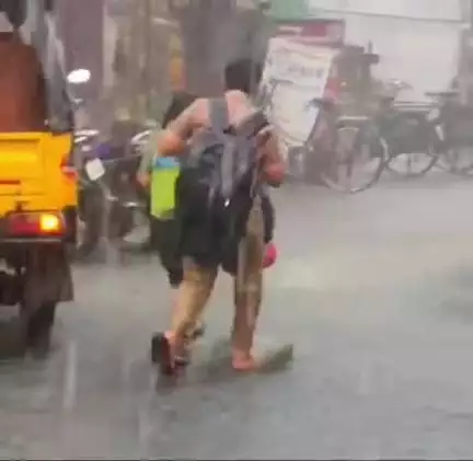 சங்கரன்கோவிலில் பலத்த மழையில் நனைந்து கொண்டே சென்ற மாணவர்கள்
