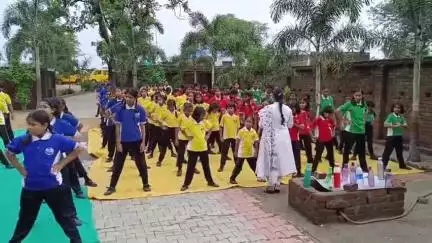 ग्रेट यूनिवर्सल पब्लिक स्कूल के प्रांगण में अंतरराष्ट्रीय योग दिवस मनाते हुए