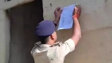 सोनबरसा: लूटकांड के फरार आरोपी के घर पुलिस ने इश्तेहार चिपकाया