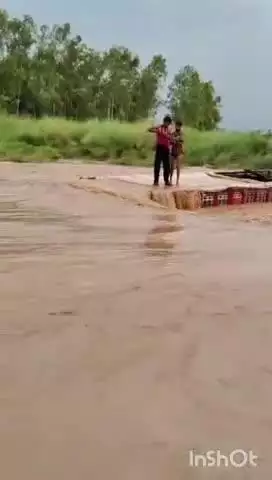 बेहट: रायपुर की नदी में तेज पानी के बीच फंसा ट्रक, चालक और परिचालक ट्रक के ऊपर चढ़े