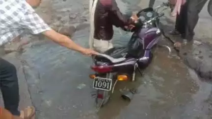 झांसी: झांसी के इलाइट चौराहे पर गंदे पानी से भरे गड्ढे में गिरा बाइक चालक, लोगों ने कड़ी मशक्कत के बाद निकाला बाहर