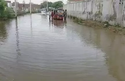 आगरा में जलभराव से परेशान हुए बाल योगी, खाट लेकर पानी से भरी सड़क पर बैठे