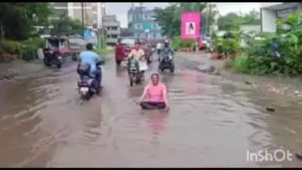 कल्याण: पेडणेकर कॉलेज परिसरात रस्त्यावर साचलेल्या पाण्यात बसून 27 गाव संघर्ष समितीच्या उपाध्यक्षांचे अनोखे आंदोलन