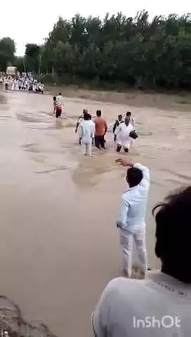 बेहट: मझाड़ी की नदी में आए तेज पानी को स्कूली बच्चे व ग्रामीण जान जोखिम में डालकर कर रहे पार