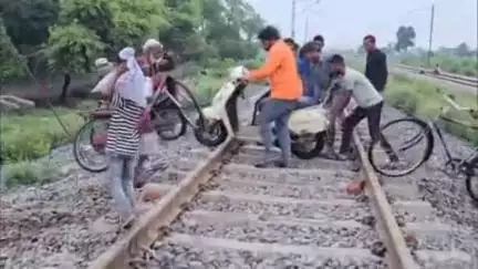 खुर्जा: मूसलाधार बारिश के बाद ईदगाह रोड स्थित अंडरपास में भरा पानी, लोग रेल की पटरी पार करने को मजबूर