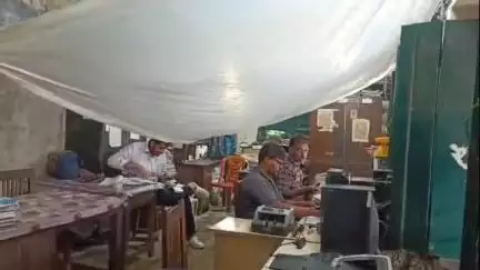 হাসনাবাদ: ছাদের ফাঁক দিয়ে টপটপ জল, ভেবিয়া পোস্ট অফিসে পলিথিন খাটিয়ে গ্রাহক পরিষেবা দিচ্ছেন কর্মীরা #Jansamasya