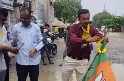 ડીસા વિપક્ષ દ્વારા નવા બસ સ્ટેશનની બહાર પડેલા ખાડાની ફુલહાર પહેરાવી પુજન કરી ભાજપનો ઝંડો ફરકાવી વિરોધ નોંધાવ્યો