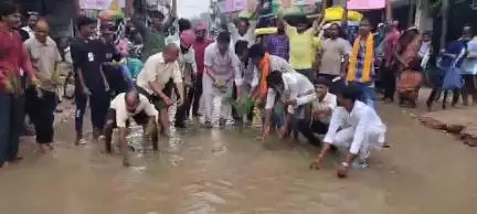 गड्ढा युक्त सड़क के मरम्मत के विरोध में धान की रोपाई करते डीएम सिंह गहरवार